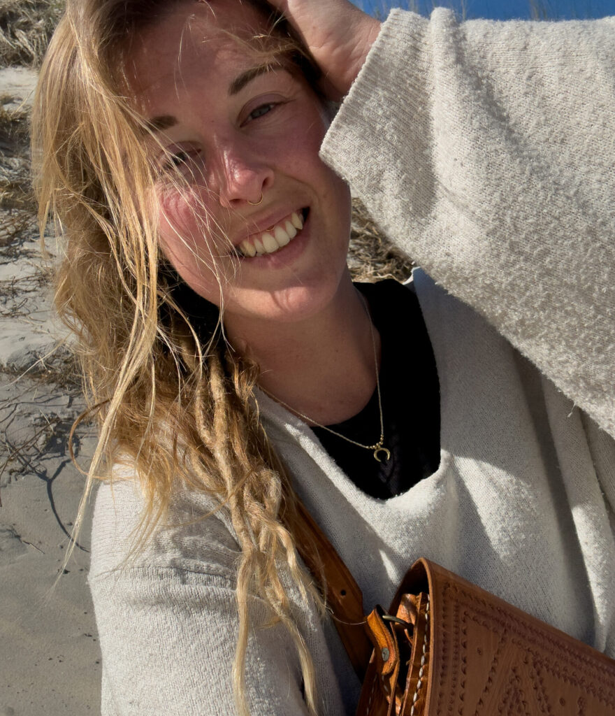 Macrame artist Amber from Namas · Sea handmade ocean inspired jewelry crafted from shells, crystals and soul sitting on a white beach in the sun