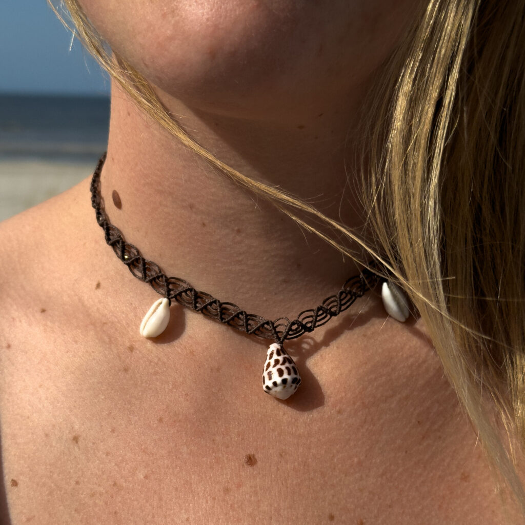 Custom made macrame necklace inspired by the ocean, made from cowrie and cone shells and tiny golden accents with brass beads. Worn at the beach